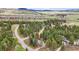 A high-angle aerial shot of a secluded home surrounded by a forest at 4185 Cheyenne Dr, Larkspur, CO 80118
