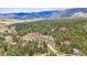 Expansive aerial view of home nestled in lush forest with mountain backdrop at 4185 Cheyenne Dr, Larkspur, CO 80118