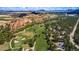 Stunning aerial view of a golf course community nestled among red rock formations and lush green trees at 4185 Cheyenne Dr, Larkspur, CO 80118