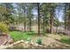 Beautiful backyard with lush green grass, mature trees, and an outdoor seating area at 4185 Cheyenne Dr, Larkspur, CO 80118