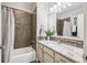 Bathroom with tiled shower and granite countertop with a decorative mirror and vanity lighting at 4185 Cheyenne Dr, Larkspur, CO 80118