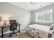Bright bedroom with a desk, bed with patterned bedding, and a window offering outdoor views at 4185 Cheyenne Dr, Larkspur, CO 80118