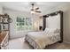 Well-lit bedroom featuring a large window, ceiling fan, and a stylish murphy bed at 4185 Cheyenne Dr, Larkspur, CO 80118