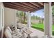 Beautiful covered patio with comfortable seating and views of the lush backyard at 4185 Cheyenne Dr, Larkspur, CO 80118