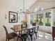 Stylish dining room featuring an elegant light fixture, a rustic table, and a large window at 4185 Cheyenne Dr, Larkspur, CO 80118