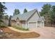 Beautiful home showcasing a three-car garage and stone accents in a tranquil, wooded setting at 4185 Cheyenne Dr, Larkspur, CO 80118