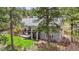 Rear exterior of home featuring a backyard, large trees, a deck and a covered patio at 4185 Cheyenne Dr, Larkspur, CO 80118