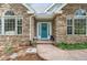 Stone home featuring a teal front door with large windows and meticulously landscaped entryway at 4185 Cheyenne Dr, Larkspur, CO 80118
