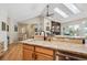 Open kitchen with granite countertops, wood cabinetry, a large island, and views to the living area at 4185 Cheyenne Dr, Larkspur, CO 80118