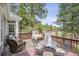 Inviting outdoor living space with wicker furniture, a glass table, and wooded views at 4185 Cheyenne Dr, Larkspur, CO 80118