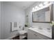 Charming bathroom with a vanity, toilet, decorative mirror, and blue walls at 11397 Kendall St, Westminster, CO 80020