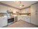 Well-lit kitchen with stainless steel appliances, custom cabinets, tile backsplash, and modern lighting at 11397 Kendall St, Westminster, CO 80020