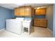Laundry room features a washer, dryer, utility sink, tile floors, and cabinets at 11397 Kendall St, Westminster, CO 80020