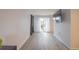 Minimalist living room with sliding glass doors, neutral paint, and hardwood floors at 11397 Kendall St, Westminster, CO 80020