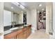 Bathroom featuring double sinks, granite countertops, and a walk-in closet at 891 14Th St # 2002, Denver, CO 80202