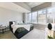 Bright bedroom with a large window offering city views and cozy decor at 891 14Th St # 2002, Denver, CO 80202