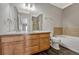 Main bathroom with double vanity, tub and dark floors at 9451 Ashbury Cir # 202, Parker, CO 80134