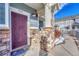 Exterior view of the home with a purple door and stone accents at 9451 Ashbury Cir # 202, Parker, CO 80134