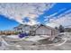 Townhouse Exterior: Building with attached garages and snow-covered parking lot at 9451 Ashbury Cir # 202, Parker, CO 80134