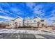 Three-unit building exterior, snow-covered parking lot at 9451 Ashbury Cir # 202, Parker, CO 80134