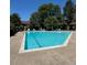 Large community pool with clear blue water surrounded by lounge chairs and lush trees at 1850 S Pitkin Cir # B, Aurora, CO 80017