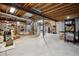 Unfinished basement with exposed wood ceiling and concrete walls at 8068 Dressage Rd, Littleton, CO 80125