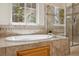Relaxing bathroom boasting a soaking tub, tiled shower, and stylish fixtures at 8068 Dressage Rd, Littleton, CO 80125