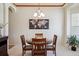 A dining room with a wooden table, four chairs, a chandelier, and a world map hanging on the wall at 8068 Dressage Rd, Littleton, CO 80125