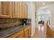 Hallway featuring granite counters, custom cabinetry, and hardwood floors overlooking an open floor plan at 8068 Dressage Rd, Littleton, CO 80125