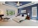 Spacious main bedroom featuring large windows, tray ceilings, and an ensuite bathroom at 8068 Dressage Rd, Littleton, CO 80125
