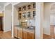 A wet bar features wooden cabinets, a granite countertop, a stainless steel sink, and a view of the stairs at 8068 Dressage Rd, Littleton, CO 80125
