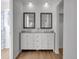 Bathroom featuring double sinks, granite countertops, framed mirrors, and wooden floor at 11427 Brownstone Dr, Parker, CO 80138