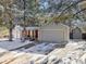 Charming home exterior featuring a two-car garage, red accents, and a snow-covered yard at 11427 Brownstone Dr, Parker, CO 80138