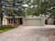 Two-story home with a brick facade, red shutters, two-car garage, and a well-manicured lawn and mature trees at 11427 Brownstone Dr, Parker, CO 80138