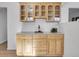 Kitchen bar area with wood cabinets, granite countertops, and glass shelving at 11427 Brownstone Dr, Parker, CO 80138