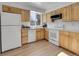 Well-lit kitchen with wood cabinets, granite countertops, and white appliances at 11427 Brownstone Dr, Parker, CO 80138