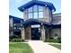 Community clubhouse with front entrance, stone pillars, and manicured lawn at 3274 S Heather Gardens Way, Aurora, CO 80014