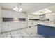 Charming kitchen featuring white cabinets, stylish tile floors, and modern lighting at 3274 S Heather Gardens Way, Aurora, CO 80014