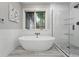 Luxurious bathroom featuring a standalone tub, glass-enclosed shower, and large windows for ample natural light at 1351 S Milwaukee St, Denver, CO 80210