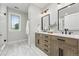 Stylish bathroom featuring double vanities with modern fixtures, wood-look cabinets, and a separate toilet area at 1351 S Milwaukee St, Denver, CO 80210