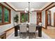 Bright dining room featuring a modern chandelier, wood trim, large windows, hardwood floors, and elegant décor at 1351 S Milwaukee St, Denver, CO 80210