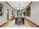 Dining room featuring hardwood floors, a tray ceiling, a modern chandelier, and natural light at 1351 S Milwaukee St, Denver, CO 80210