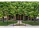 Beautiful home with stone facade, covered entrance, and mature trees framing the property at 1351 S Milwaukee St, Denver, CO 80210