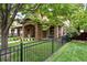 Attractive home with stone accents, a covered porch, and a black metal fence surrounding the property at 1351 S Milwaukee St, Denver, CO 80210
