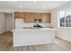 Modern kitchen features a central island, wood cabinets, stainless steel appliances and laminate floors at 1281 Rock Cliff Ave, Erie, CO 80516