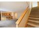 Finished basement boasts a wet bar with seating and carpeted staircase at 1550 Ajax St, Strasburg, CO 80136