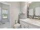 Bright bathroom with decorative mirror, sink, and access to a standing shower at 1550 Ajax St, Strasburg, CO 80136
