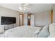 Well-lit bedroom features a bed, ceiling fan, and three entry doors at 1550 Ajax St, Strasburg, CO 80136