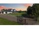 Charming two-story home with a large front yard, gated entry, and beautiful landscaping at sunset at 1550 Ajax St, Strasburg, CO 80136