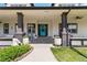 Charming front porch featuring a bright blue front door, decorative columns, and decorative planters at 1550 Ajax St, Strasburg, CO 80136